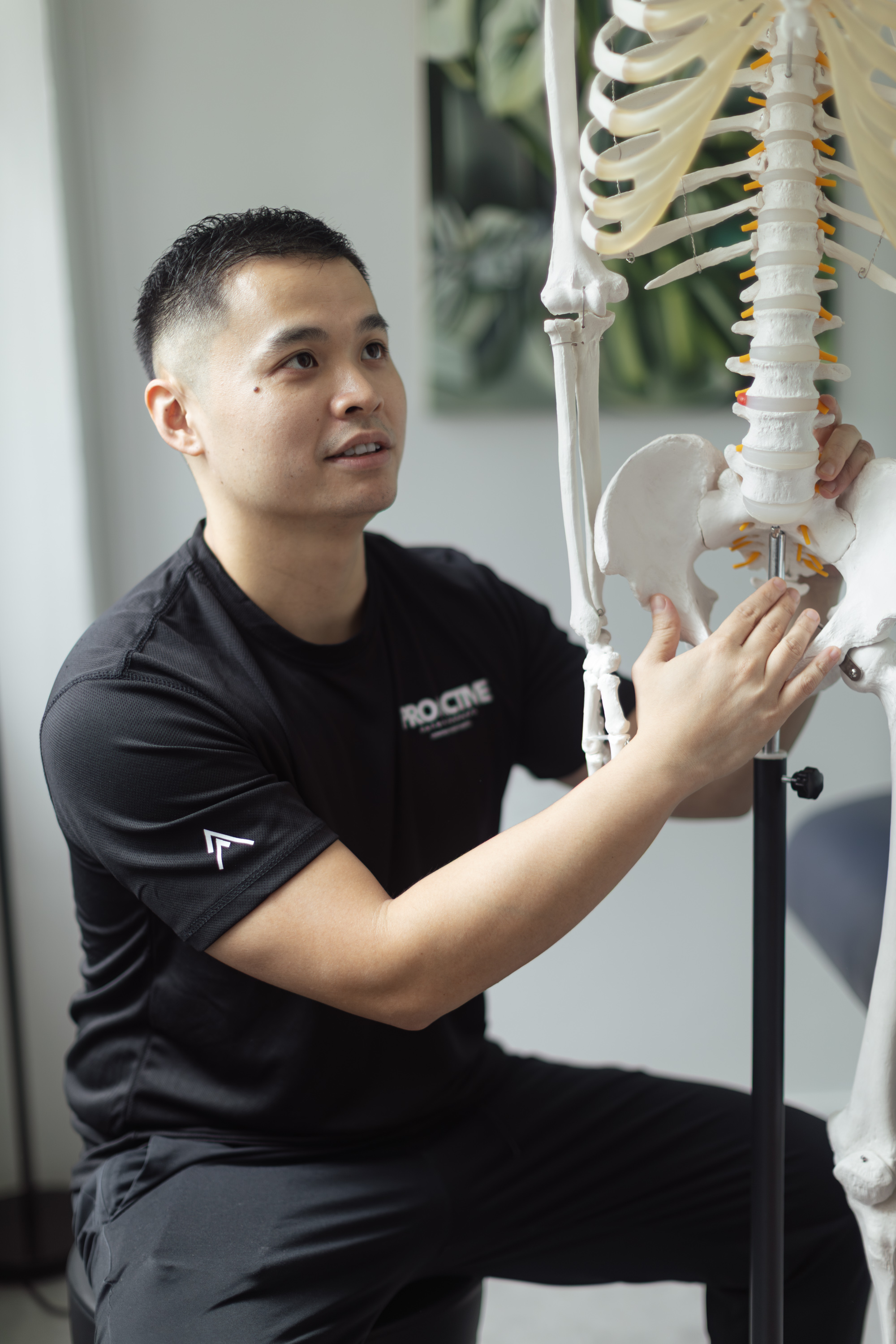 ProActive physiotherapist explaining spinal anatomy with a model