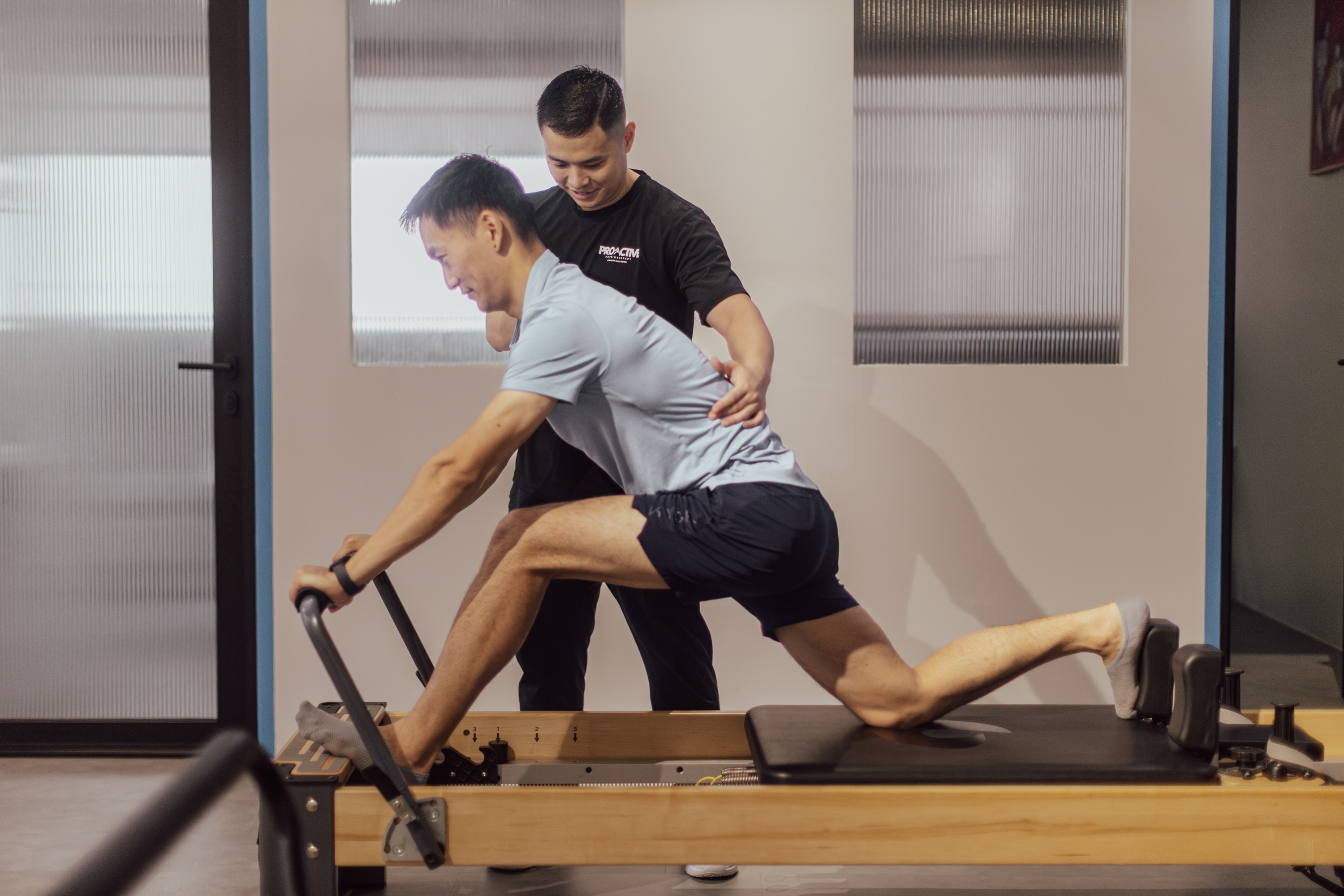 Physiotherapist guiding a reformer Pilates lunge